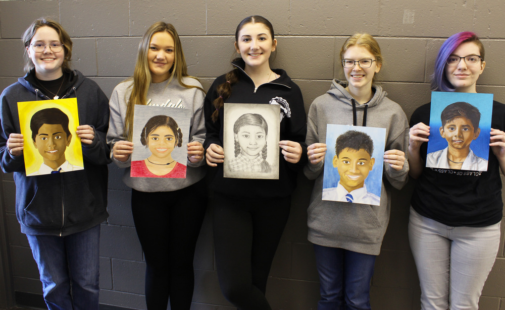 Students holding artwork for the Memory Project